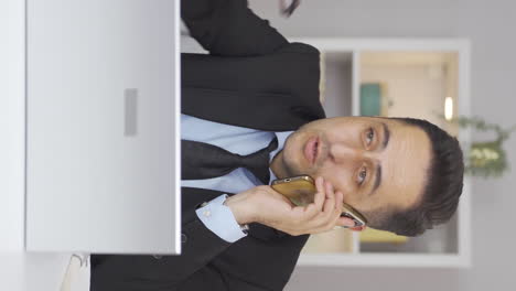 Vertical-video-of-Home-office-worker-man-speaks-on-the-phone-in-managerial-qualifications.